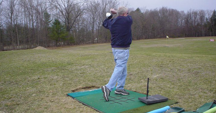man practicing golf swing