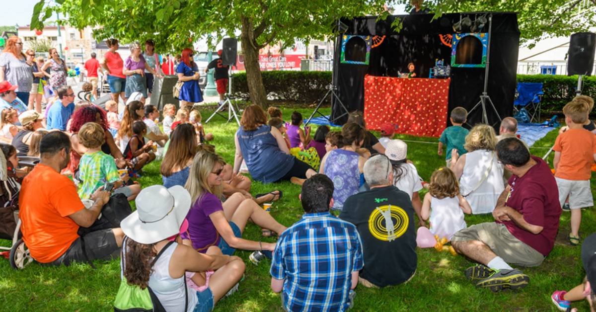 people on lawn watchng a puppet show